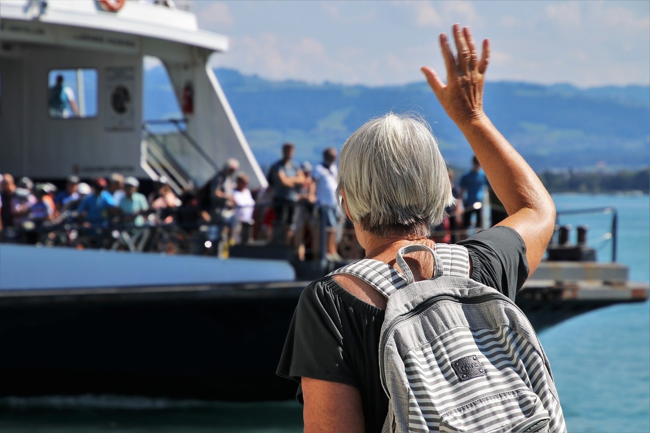 femme avec un sac devant un bateau